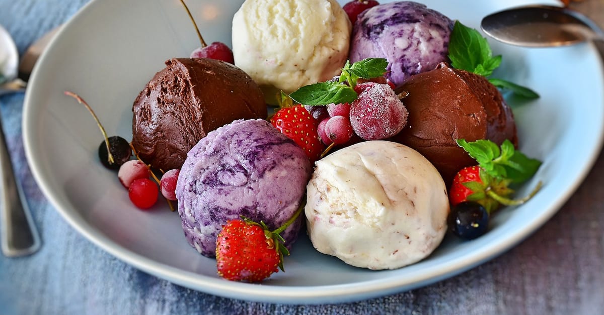 Keto ice cream with berries in blue bowl on wooden table