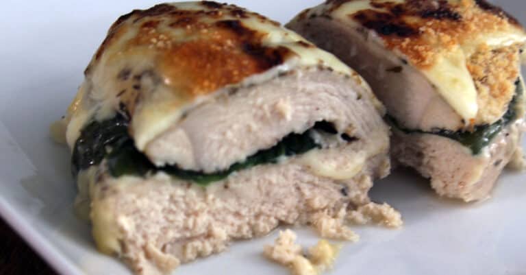 Stuffed, baked chicken on white plate