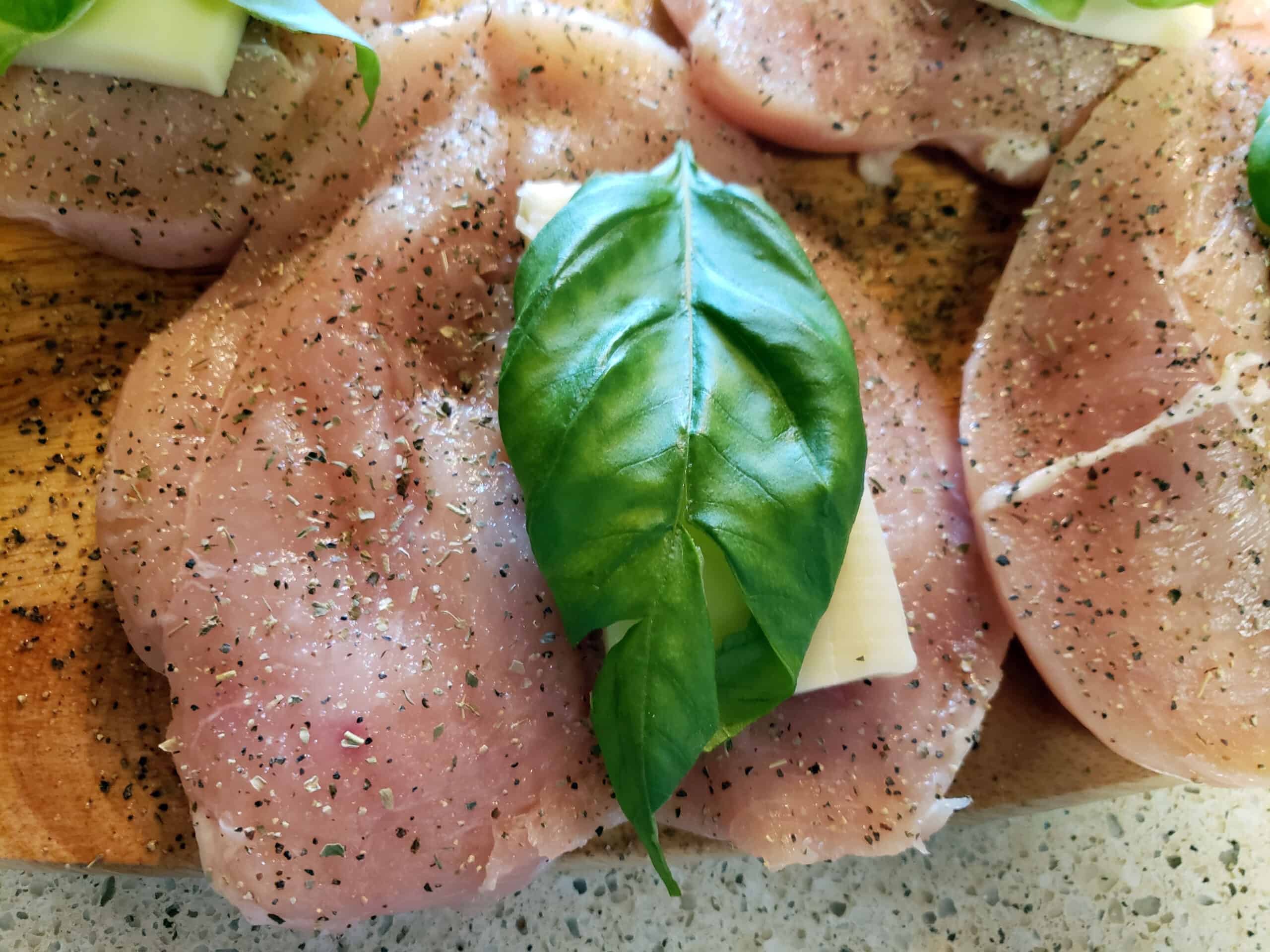 cheese and fresh basil on butterflied chicken breast