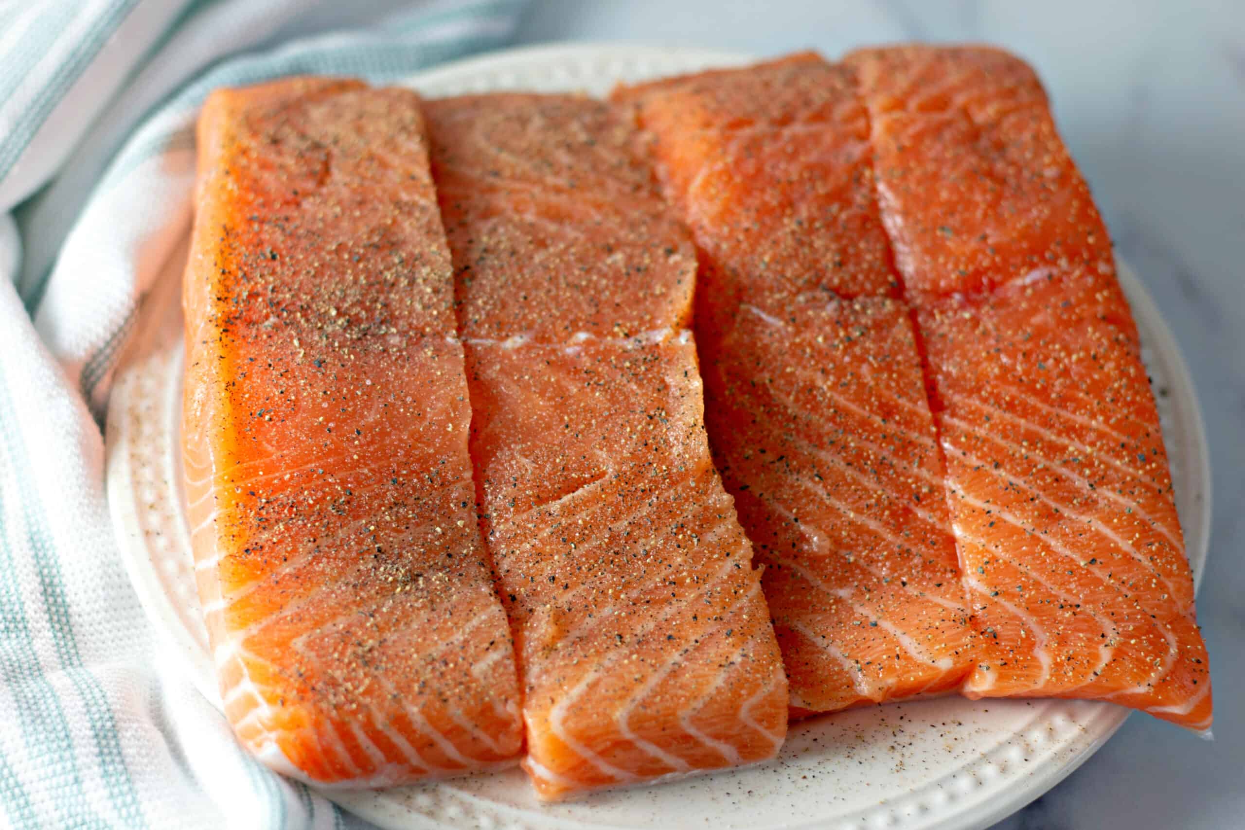 seasoned salmon fillets on white plate